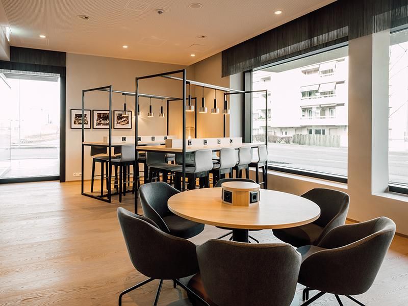 מתחם עבודה משותף עם עיצוב מינימליסטי וחלונות גדולים