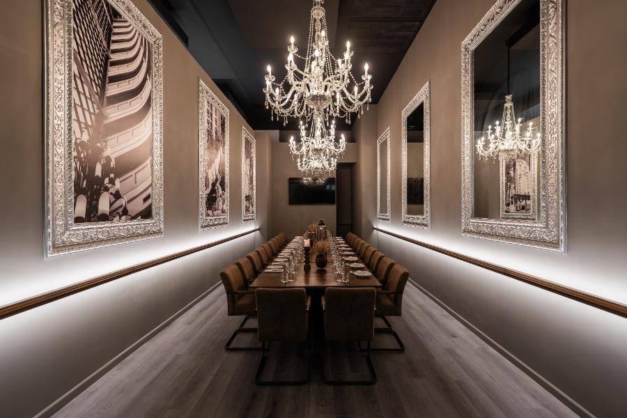 חדר פרטי יוקרתי במתחם ארמונות הרודס אילת, עם נברשות קריסטל, מראות דקורטיביות ושולחן לאירועים