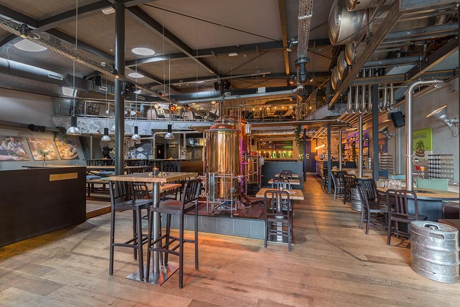 חלל מודרני עם מבשלת בירה, ספות ישיבה ונברשות תעשייתיות