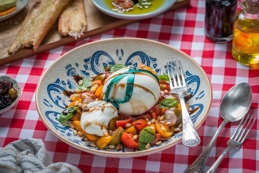 סלט קפרזה עם מוצרלה, עגבניות שרי ובזיליקום, מוגש עם חומץ בלסמי