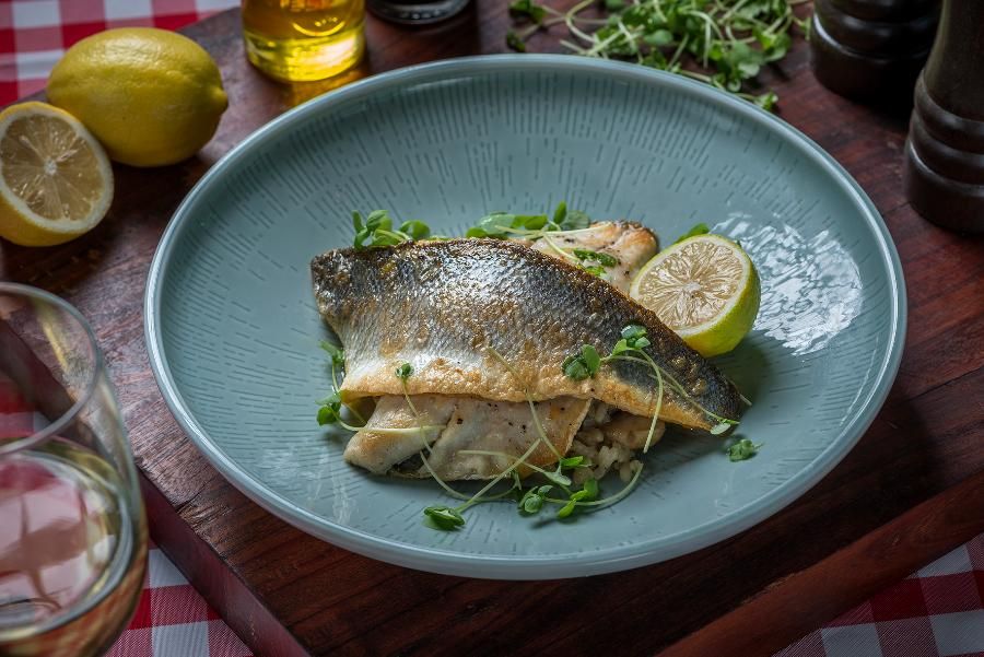 דג צלוי מוגש עם אורז ולימון על צלחת אלגנטית