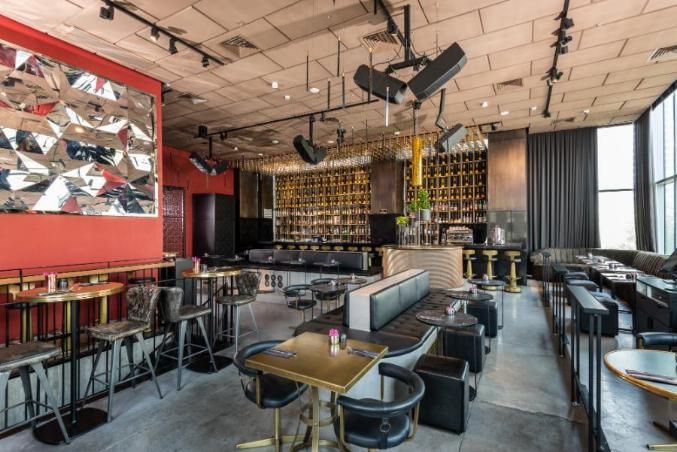 מסעדת המלון רוטשילד 22 תל אביב – חלל מסעדה  עם שולחנות וכיסאות שחורים לצד בר יוקרתי  