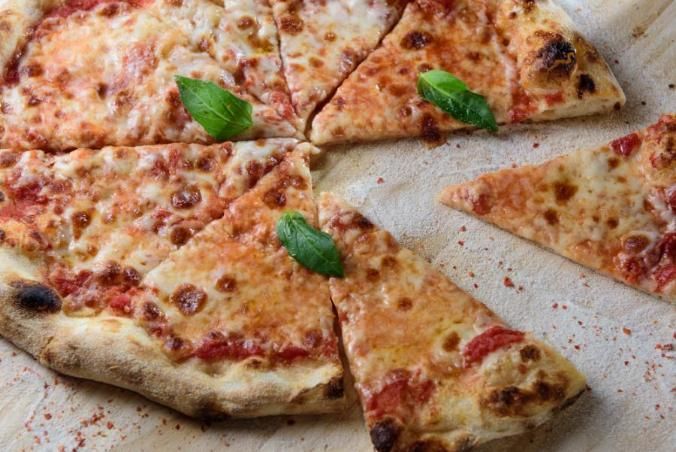 פיצה מרגריטה קלאסית עם גבינת מוצרלה, רוטב עגבניות ועלי בזיליקום טריים