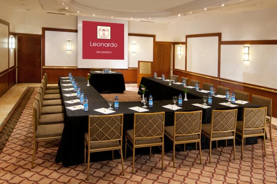 חדר ישיבות מאובזר במלון לאונרדו ירושלים, כולל מקרן, מים מינרליים וניירות כתיבה
