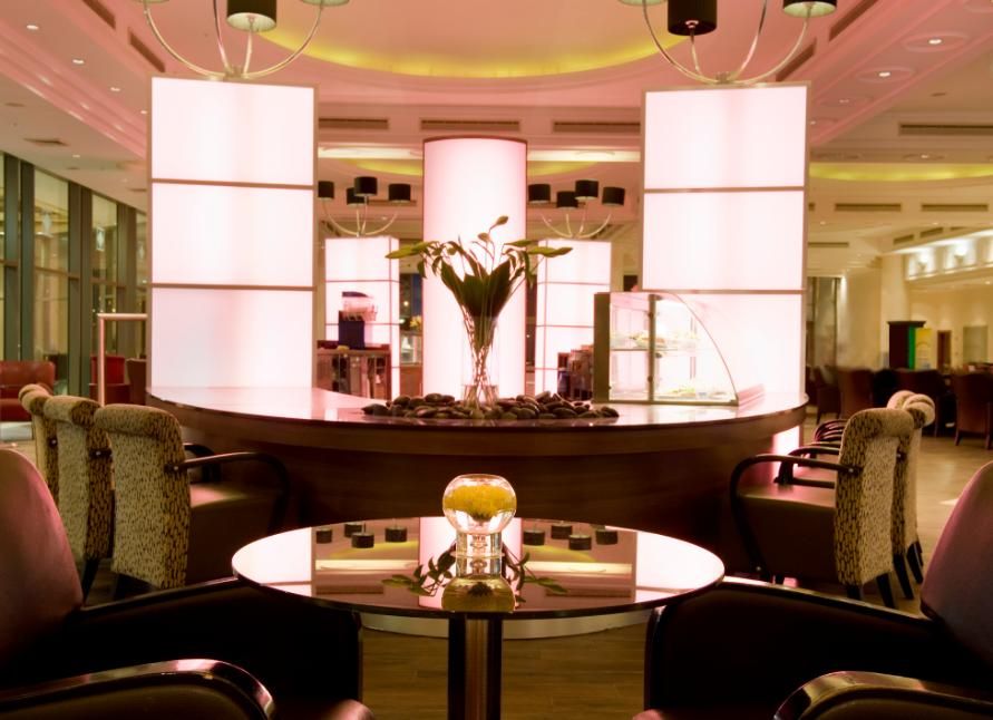 פינת ישיבה אלגנטית במלון, עם שולחנות זכוכית, כורסאות מרופדות ותאורה רכה בסגנון מודרני