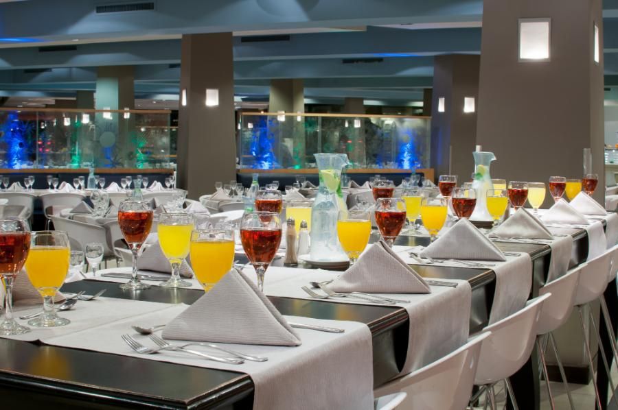 שולחן ערוך עם מפות לבנות וכוסות יין עם שתיה קלה 