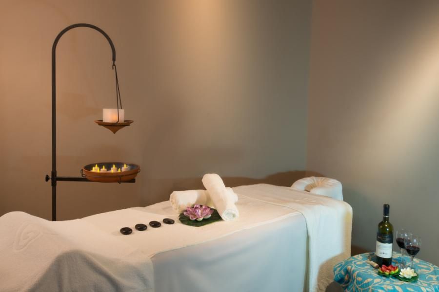 חדר טיפולים מפנק עם מיטת מסאז', נרות ויין אדום